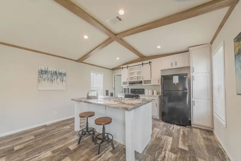 A kitchen in a mobile home with a large island and stools.