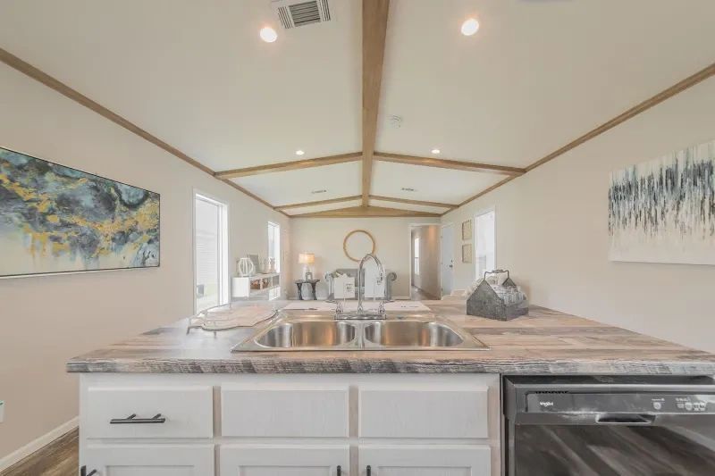 A kitchen in a mobile home with a sink and a dishwasher.
