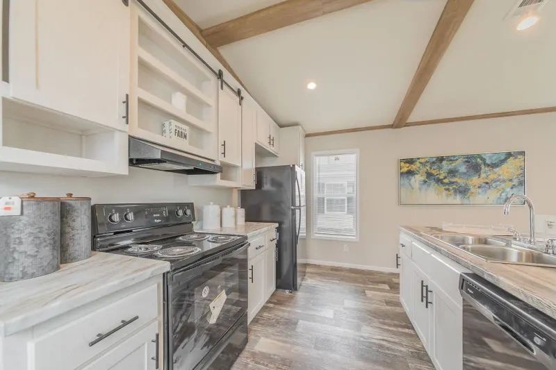 A kitchen with a stove , dishwasher , refrigerator and sink.