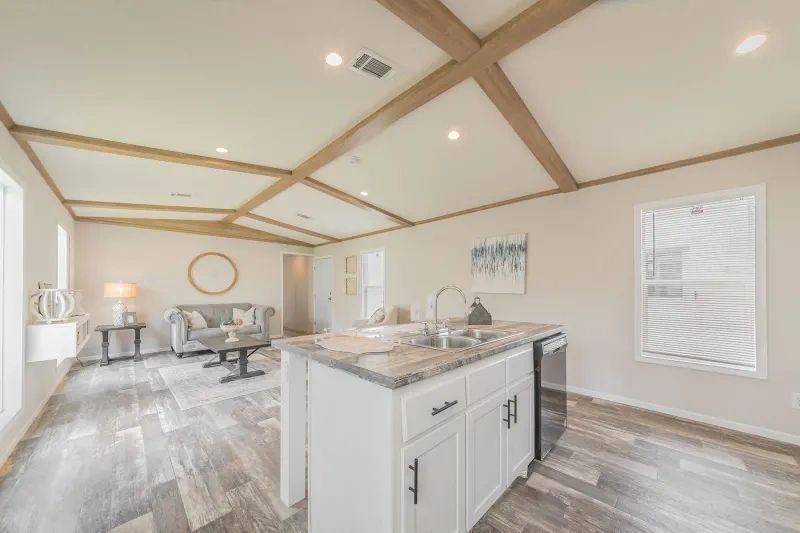 A kitchen in a mobile home with a large island in the middle of the room.