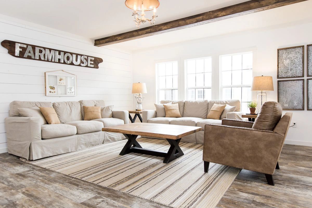 A living room filled with furniture and a sign that says farmhouse.