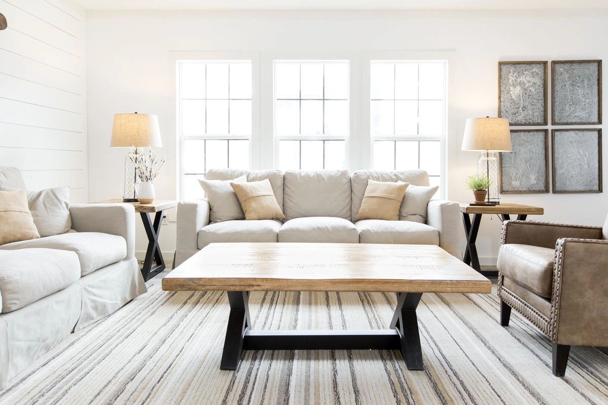 A living room with a couch , chairs , and a coffee table.