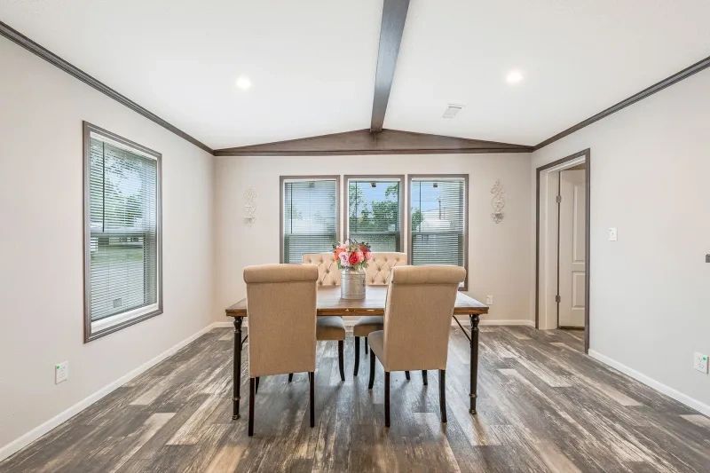 A dining room with a table and chairs in a mobile home.
