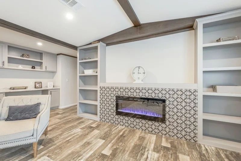 A living room with a fireplace , chair , and shelves.