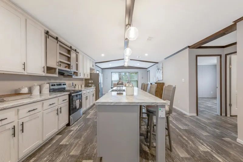 A kitchen in a mobile home with a large island in the middle.