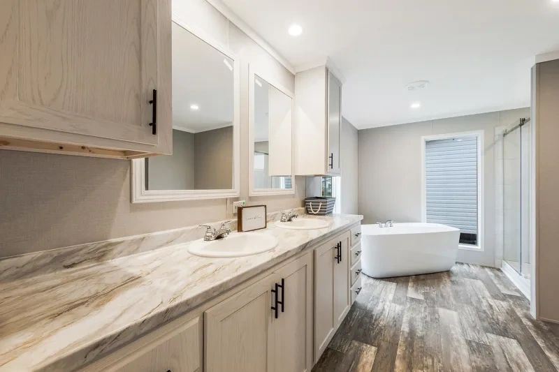 A bathroom with two sinks , two mirrors and a tub.