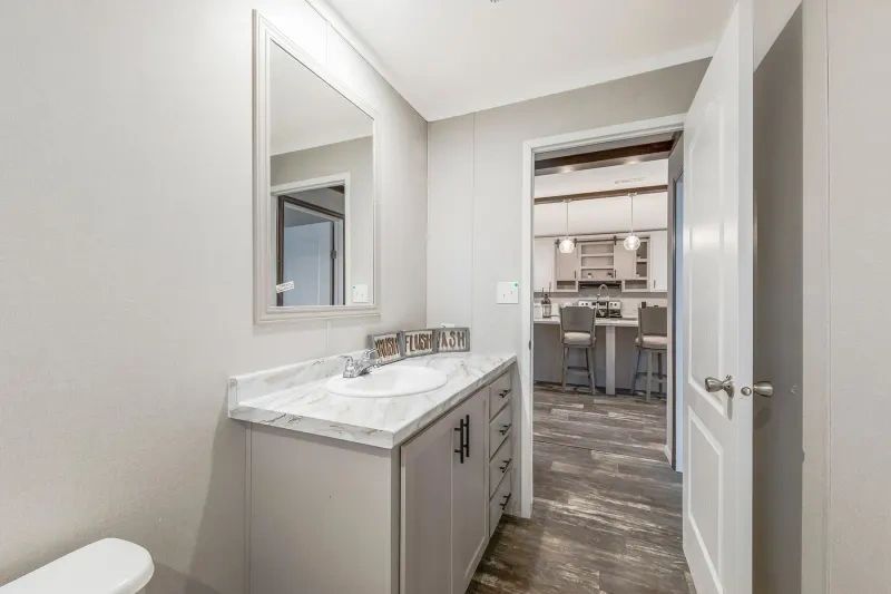 A bathroom with a sink , toilet and mirror.