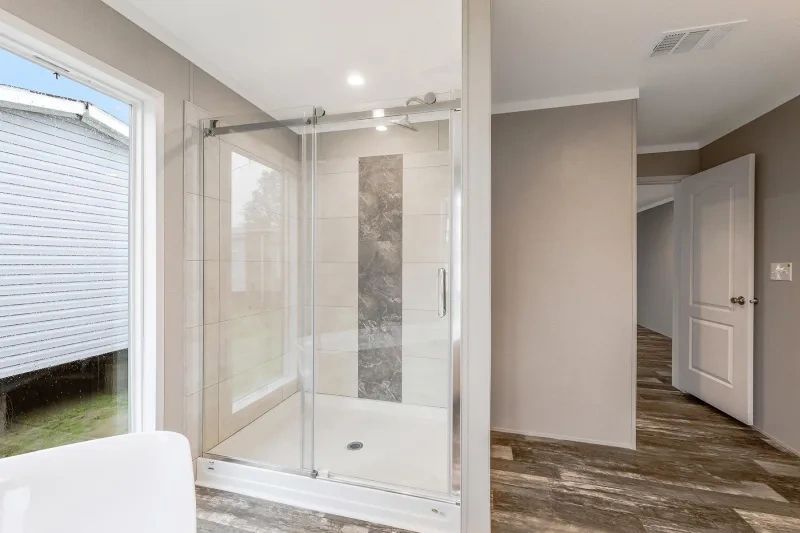 A bathroom with a walk in shower and a tub.