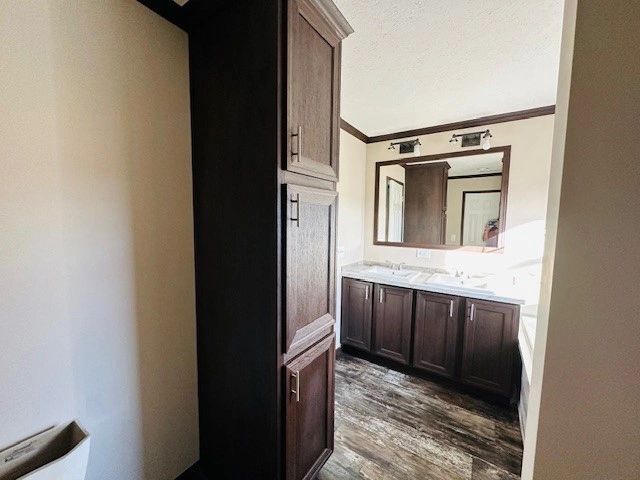 A bathroom in a mobile home with a sink , mirror and cabinets.