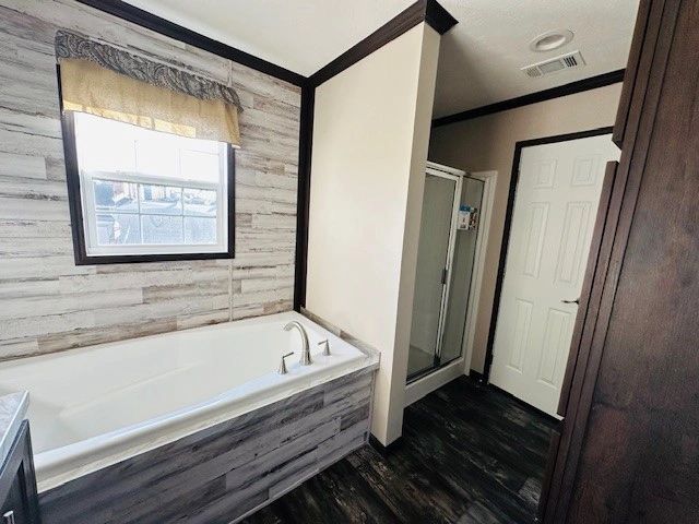 A bathroom with a tub , shower and window.