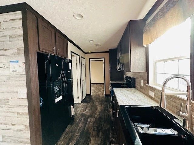 A kitchen with a sink , refrigerator , and microwave.