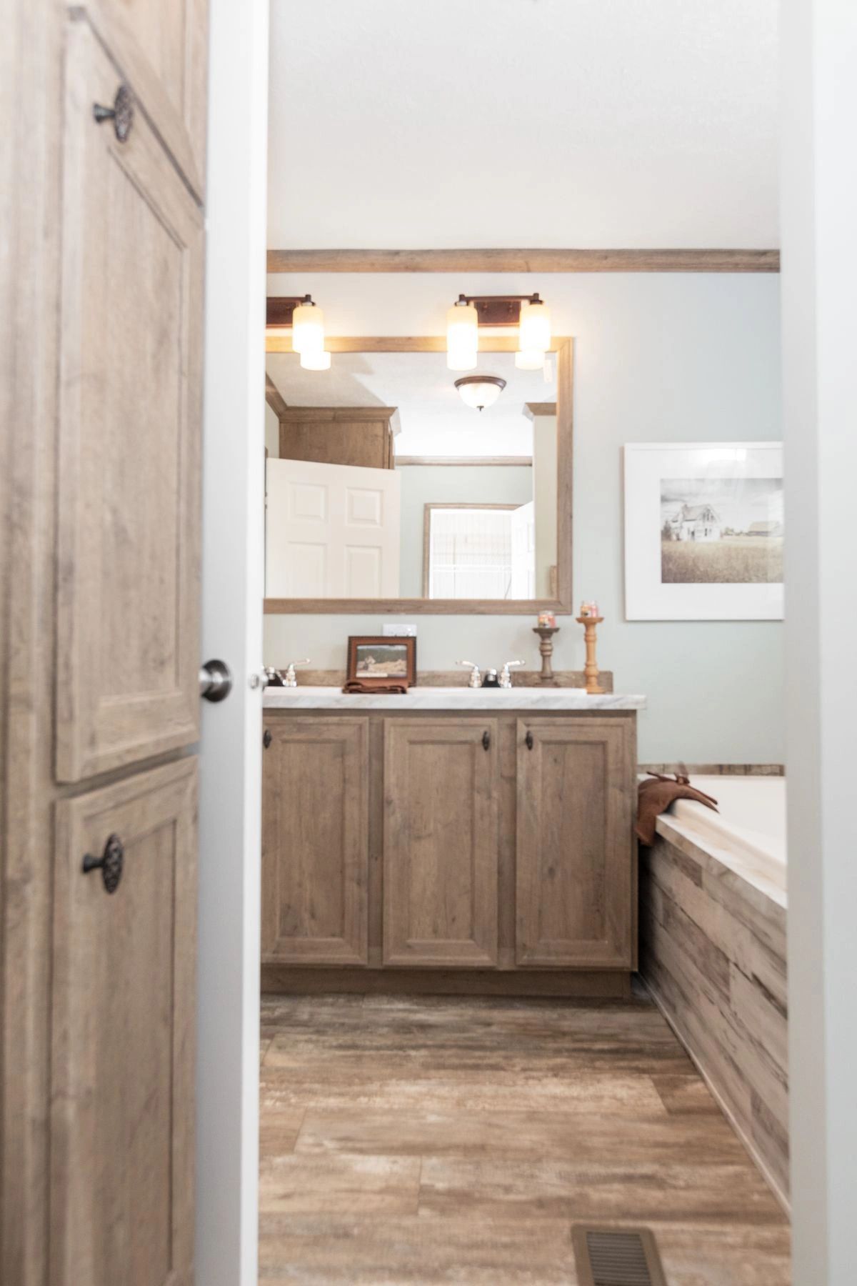 A bathroom with two sinks , a tub and a mirror.