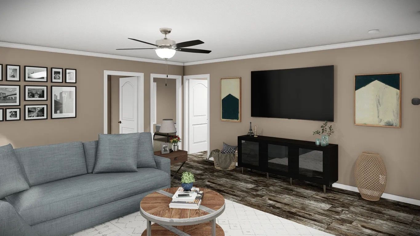 A living room with a couch , coffee table , television and ceiling fan.
