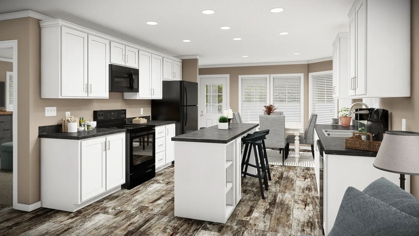 A kitchen with white cabinets , black appliances , and a large island.