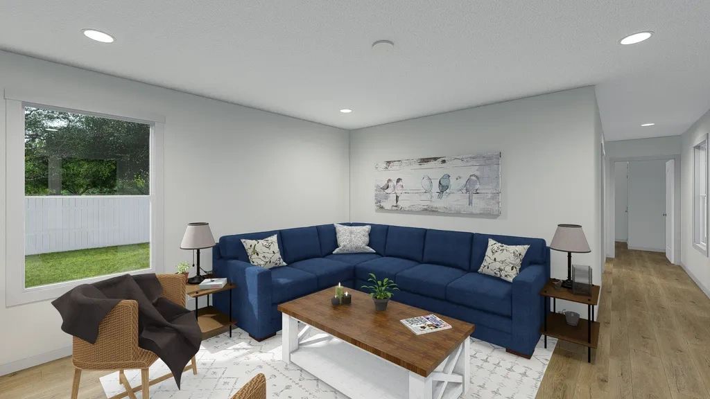 A living room with a blue sectional couch and a coffee table.
