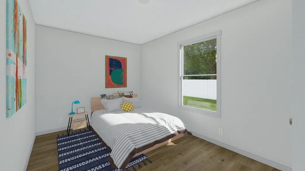 A bedroom with a bed , rug , desk and window.