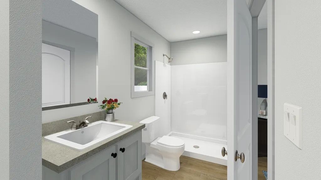 A bathroom with a sink , toilet , shower and mirror.