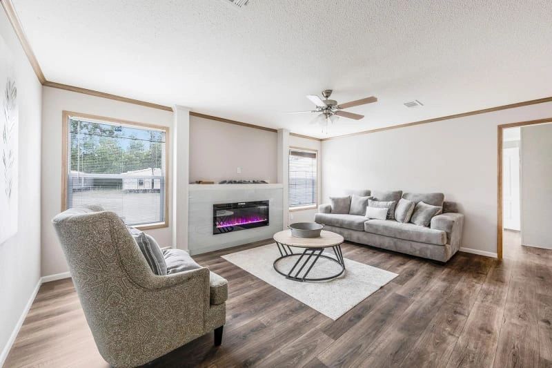 A living room with a couch , chair , coffee table and fireplace.