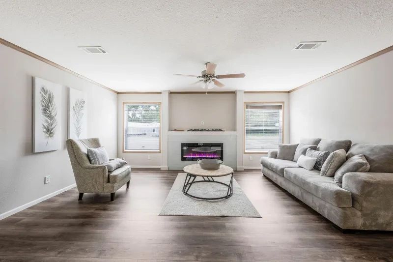 A living room with a couch , chair , coffee table and fireplace.