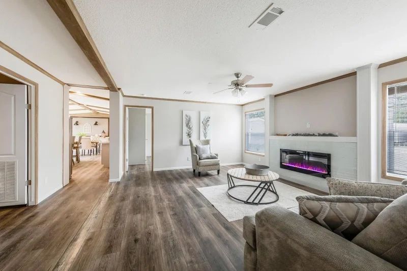 A living room with hardwood floors , a fireplace , a couch and chairs.