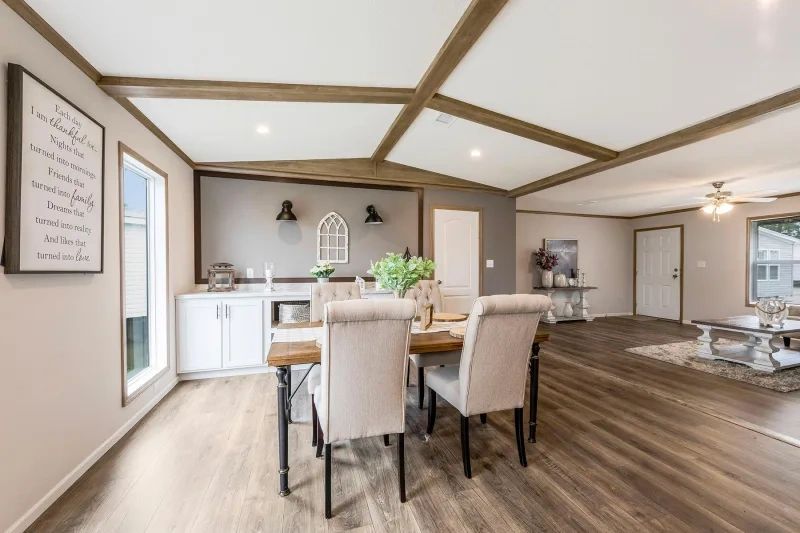 A dining room in a mobile home with a table and chairs.