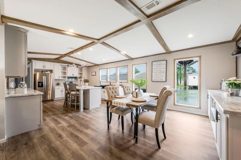 A kitchen and dining room in a mobile home with a table and chairs.