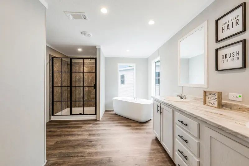 A bathroom with a tub , sink , mirror and walk in shower.