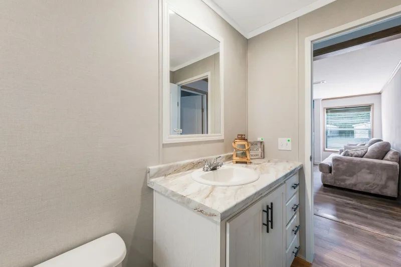 A bathroom with a sink , toilet and mirror.