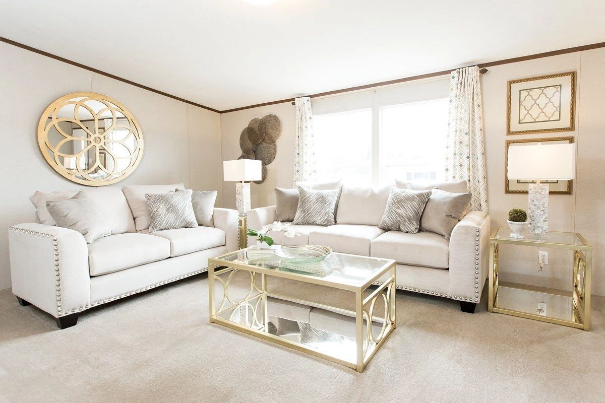 A living room with two couches , a coffee table , and a mirror.