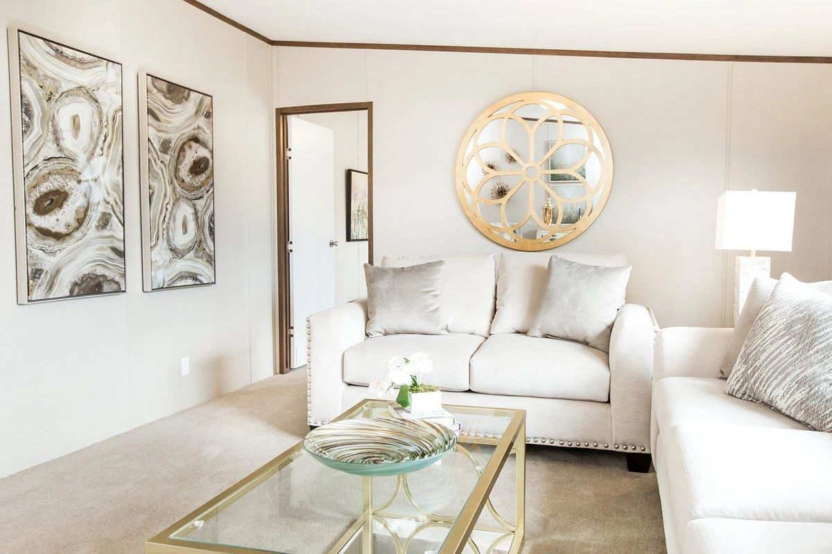 A living room with two couches , a coffee table , and a clock on the wall.