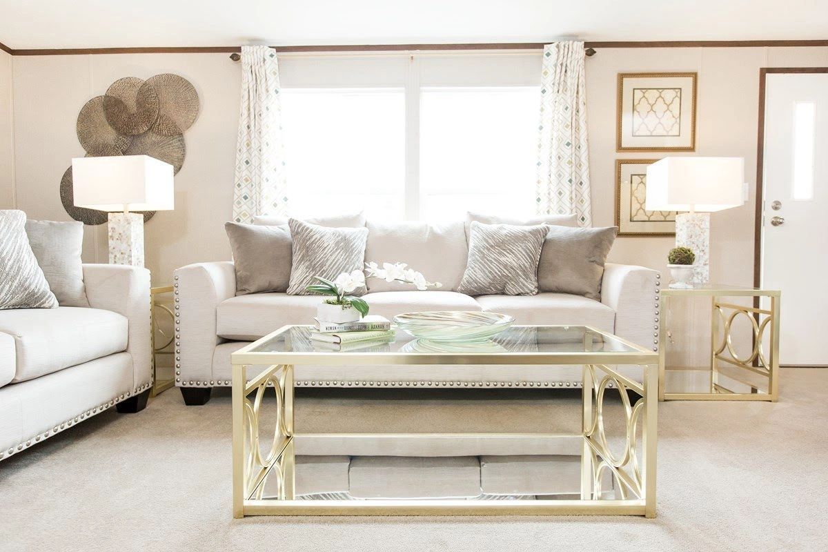 A living room with a couch , chair , coffee table and lamps.