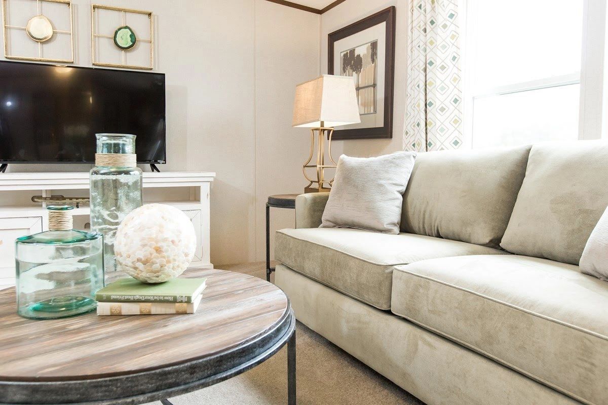 A living room with a couch , coffee table , and television.