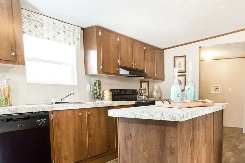 A kitchen with wooden cabinets and a large island in the middle.
