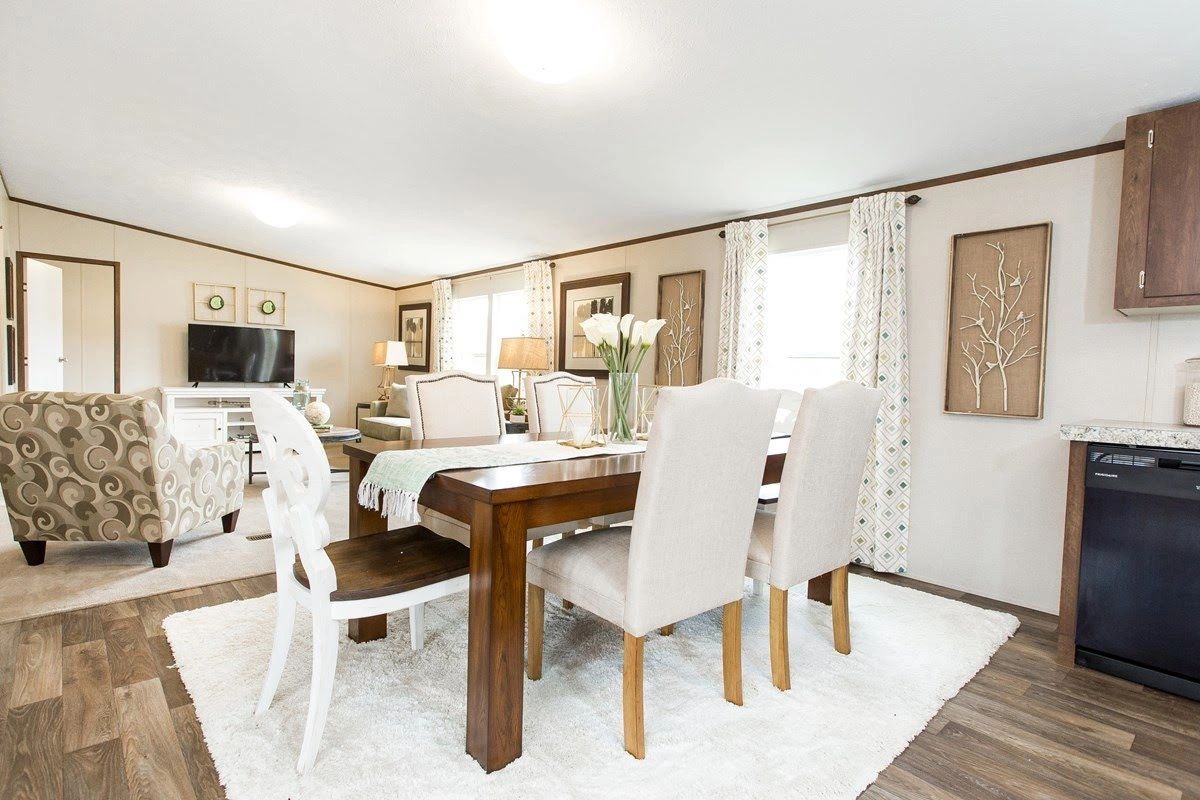 A dining room with a table and chairs in a mobile home.