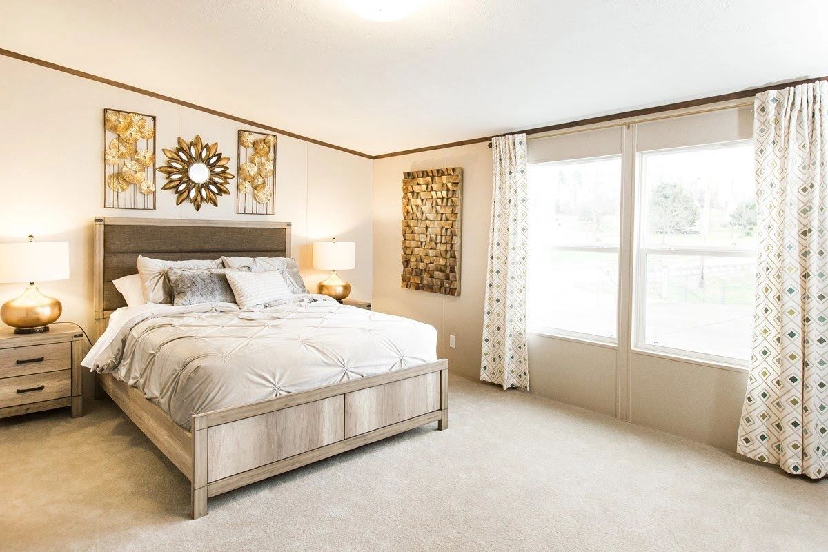 A bedroom with a king size bed and two windows.