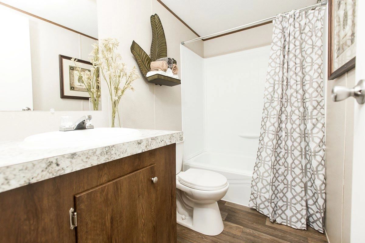 A bathroom with a toilet , sink and shower curtain.