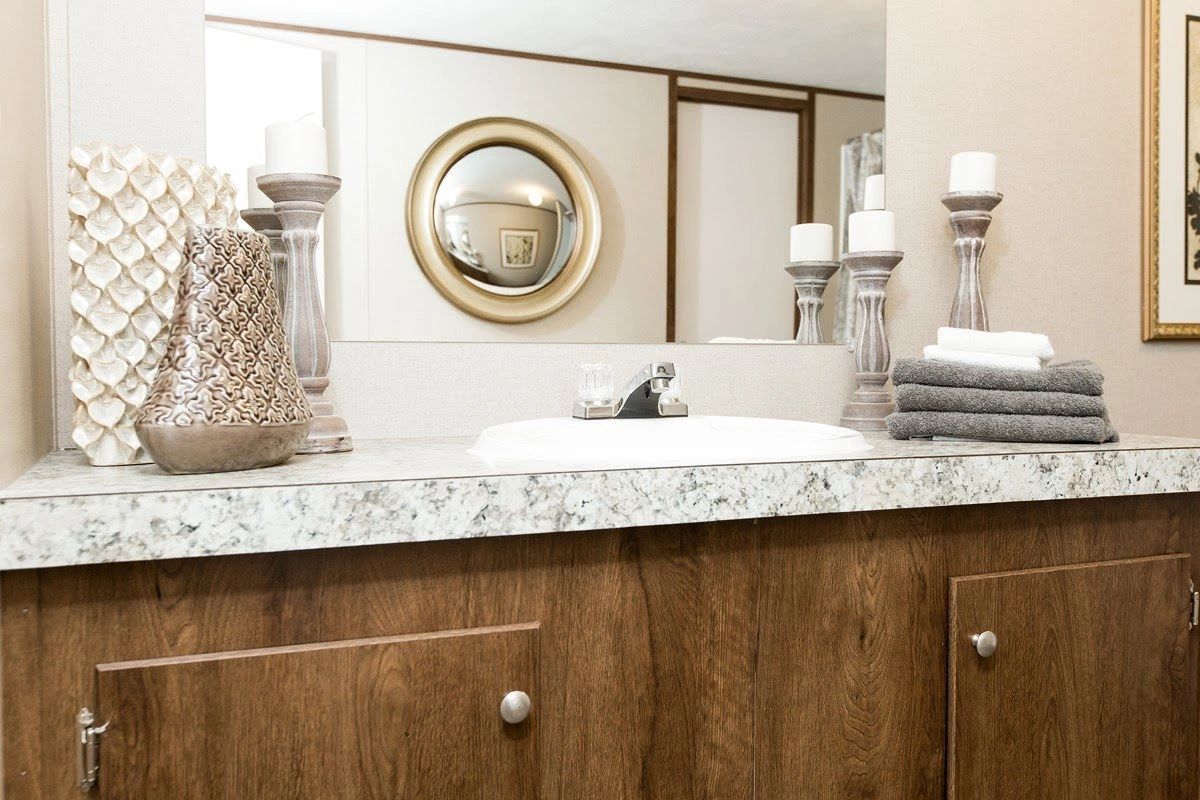 A bathroom with a sink , mirror and towels on the counter.