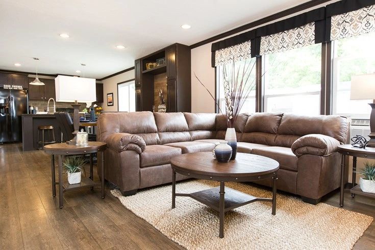 A living room with a large sectional couch and a coffee table.