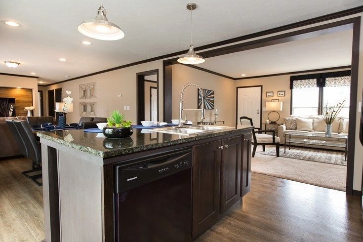 A kitchen with a large island and a dishwasher in a house.