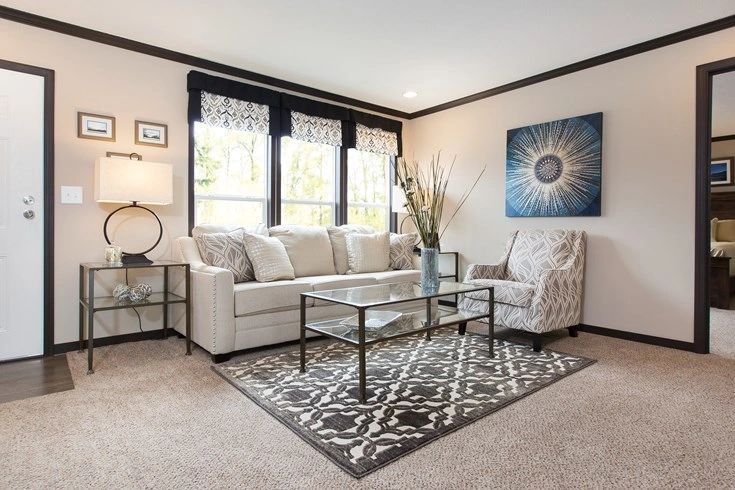 A living room with a couch , chair , coffee table and rug.