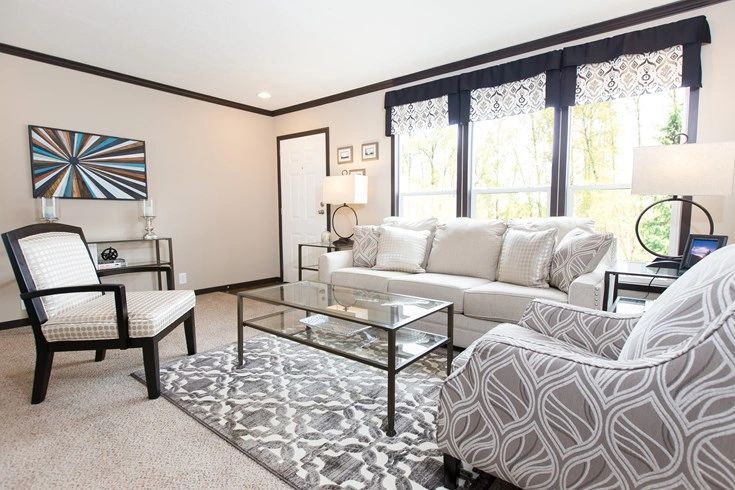 A living room with a couch , chairs , and a coffee table.