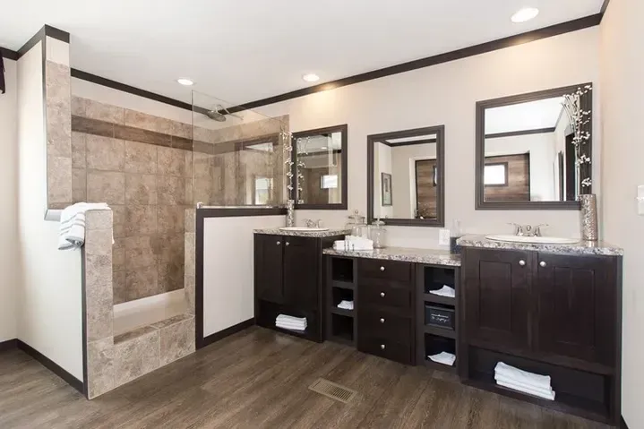 A bathroom with two sinks and a walk in shower.
