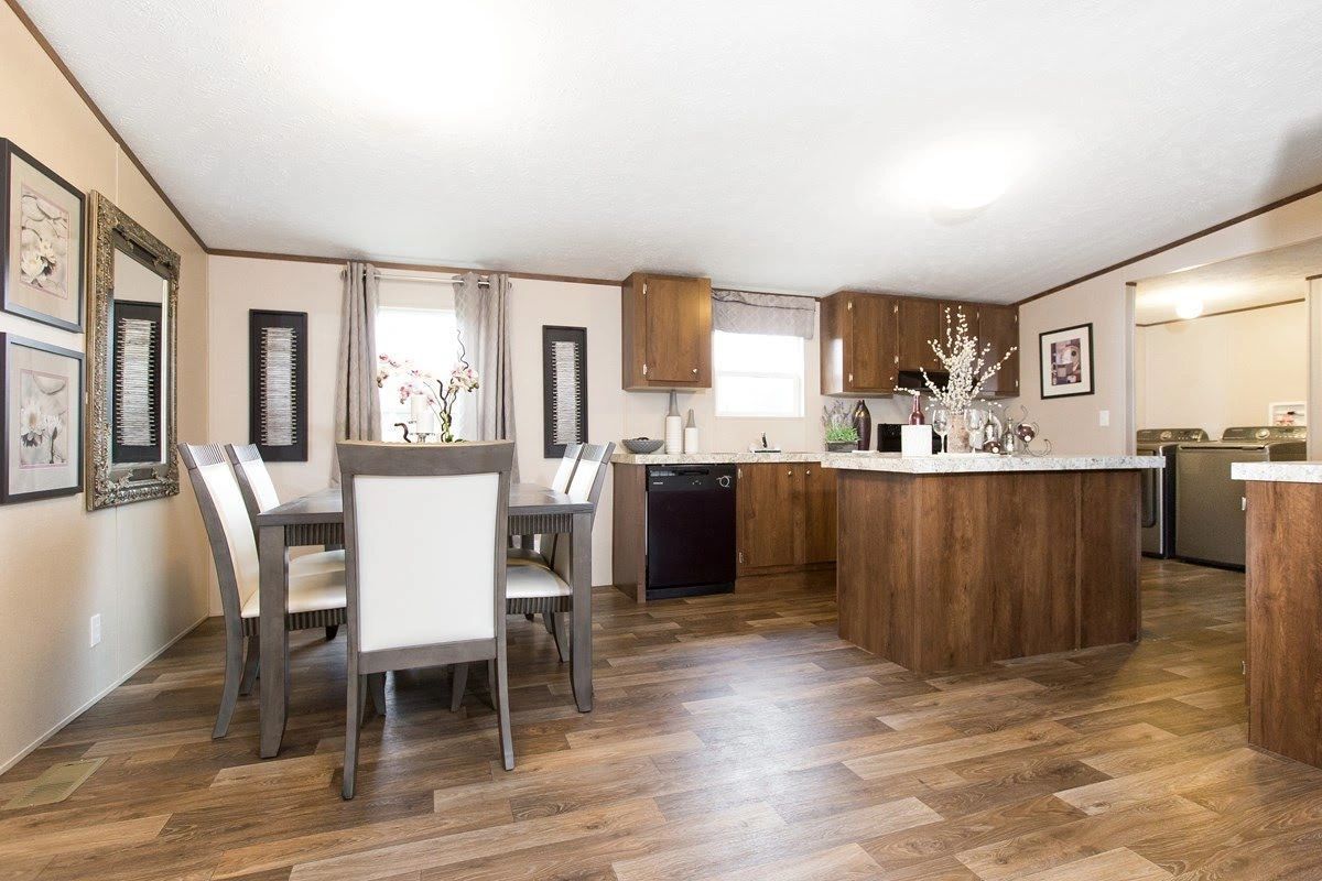 A kitchen and dining room in a mobile home with a table and chairs.