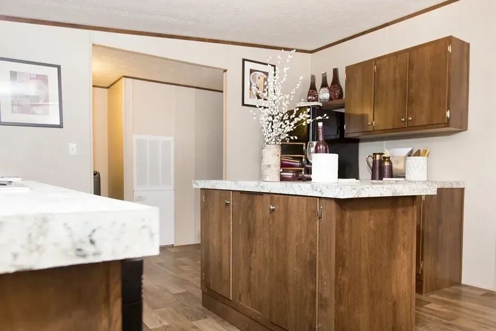 A kitchen with wooden cabinets and a marble counter top.