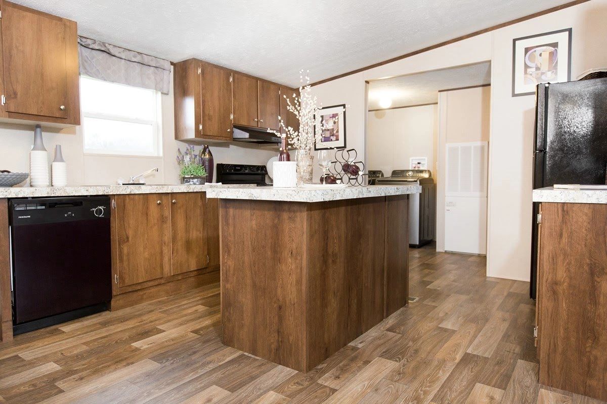 A kitchen in a mobile home with a large island in the middle.