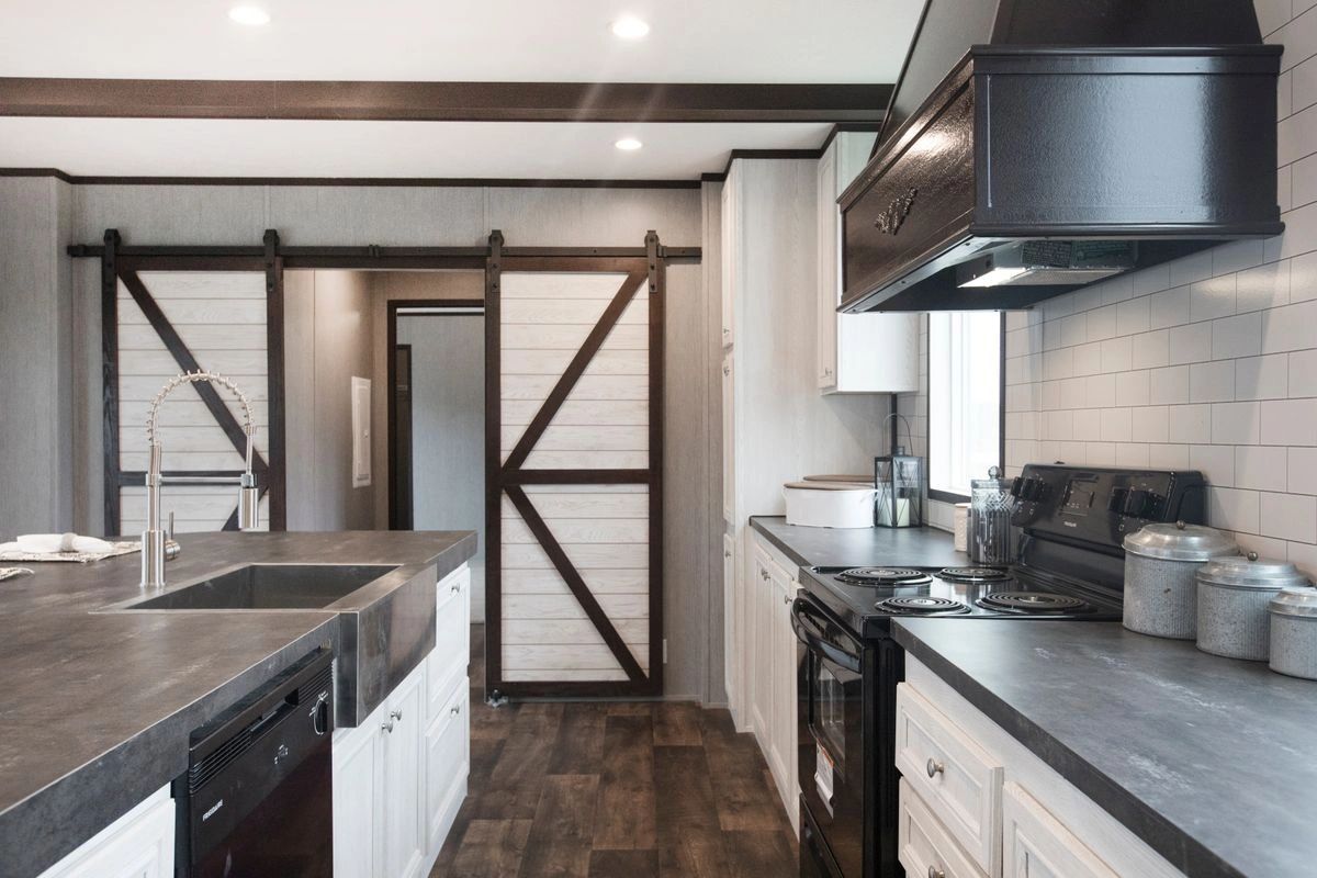 A kitchen with a sliding barn door and a sink.
