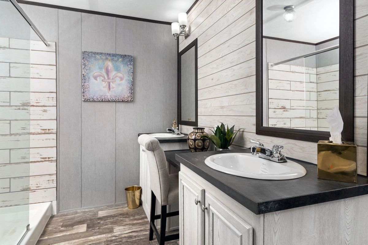 A bathroom with a sink , mirror and shower.