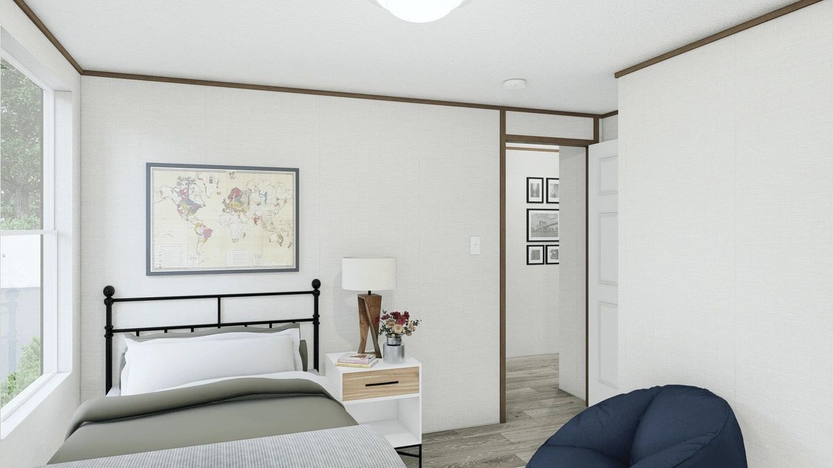 A bedroom with a bed , chair , nightstand and window.