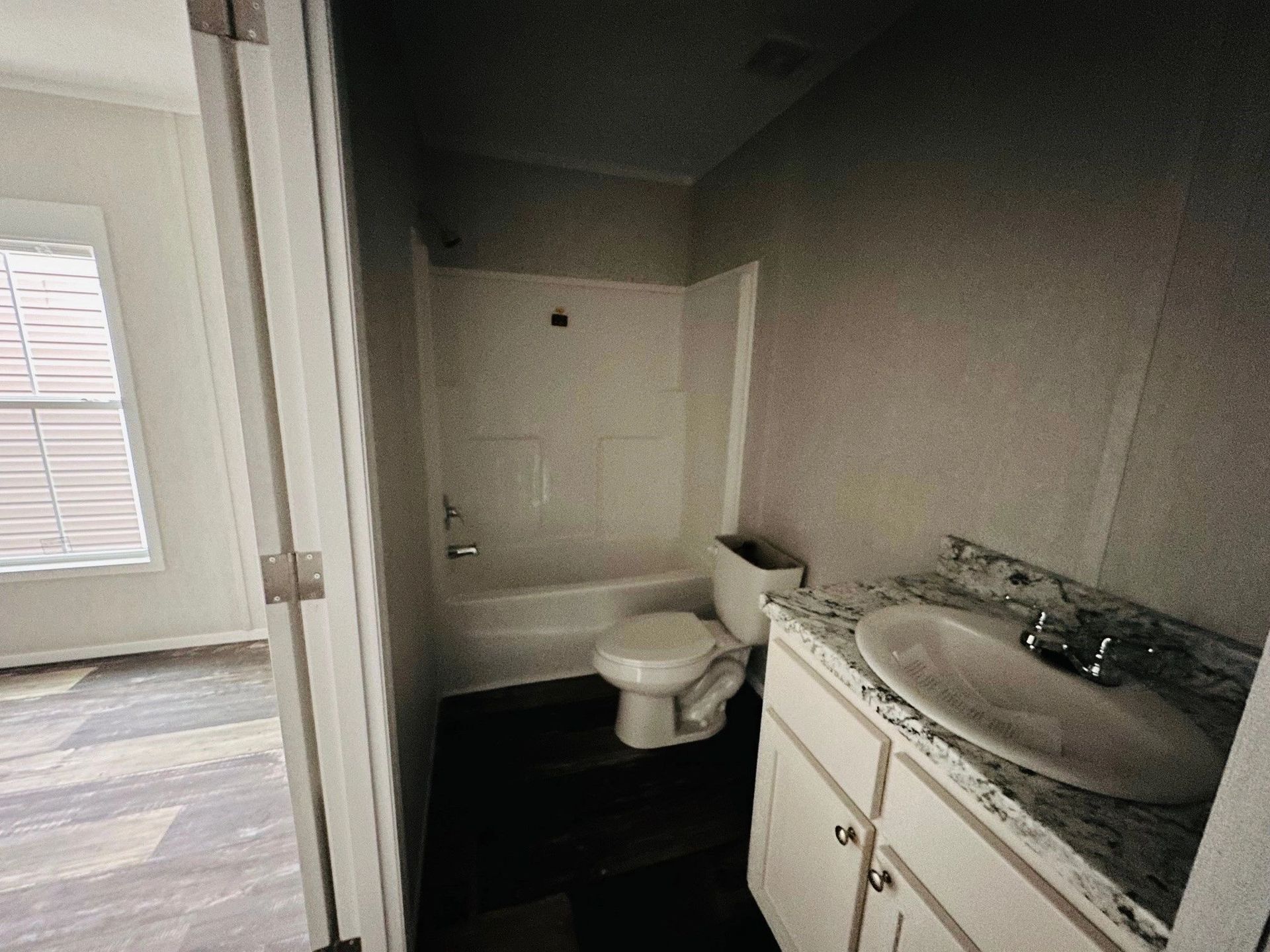 A bathroom with a toilet , sink and bathtub.