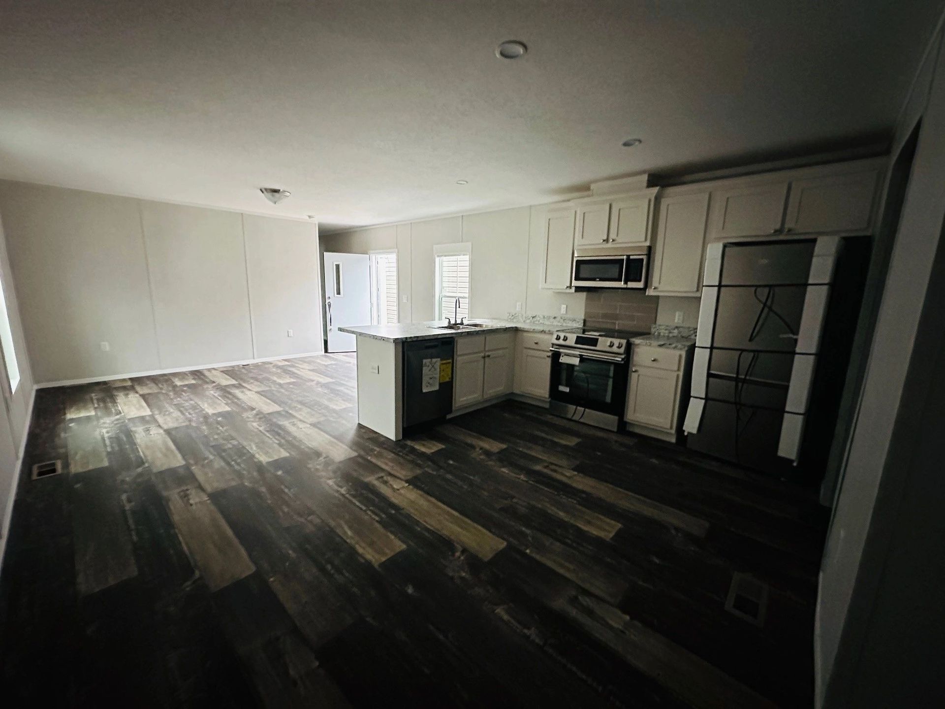 A kitchen with a stove , refrigerator , microwave , and sink.